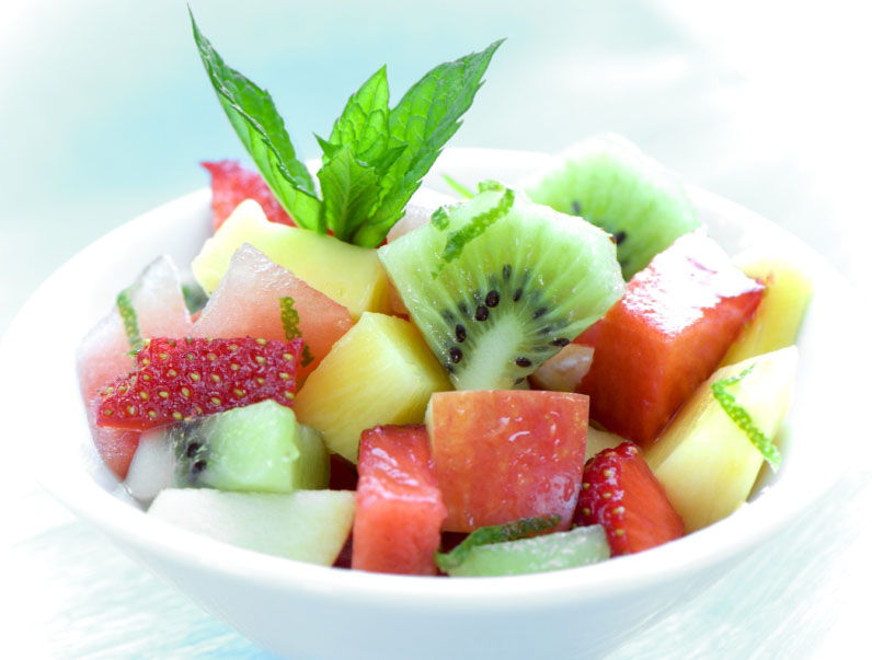 healthy and deliciously looking bowl of fruit salad on blue background
