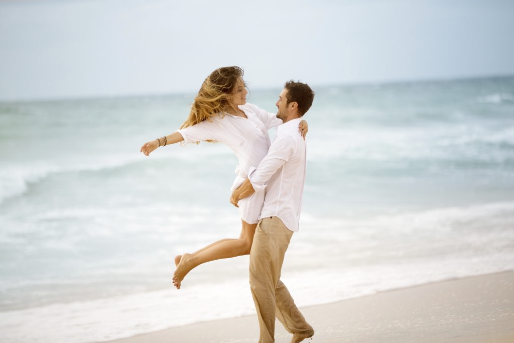 Young couple enjoying each other on a beach.