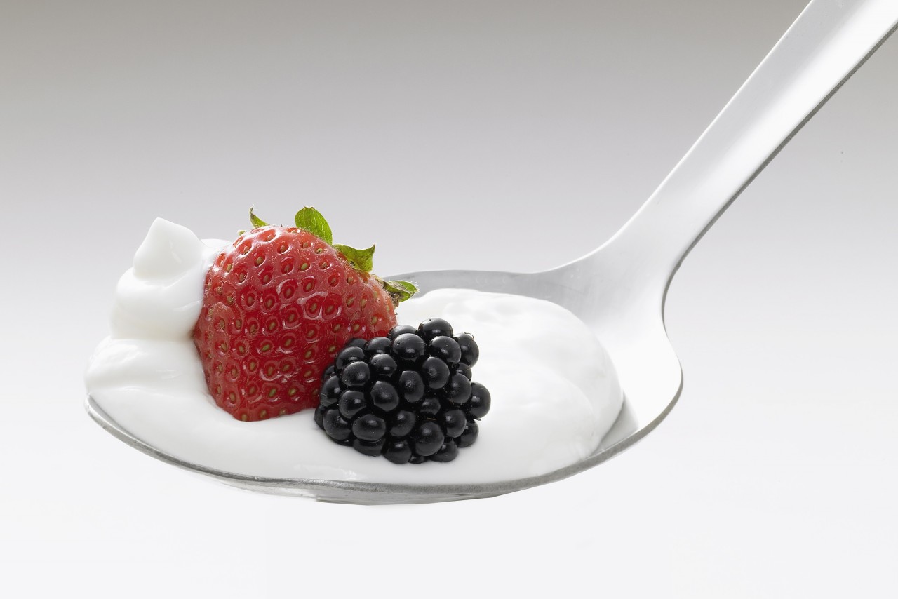 Close up of spoon with yoghurt, strawberry and blackberry --- Image by © Knut Schulz/Westend61/Corbis